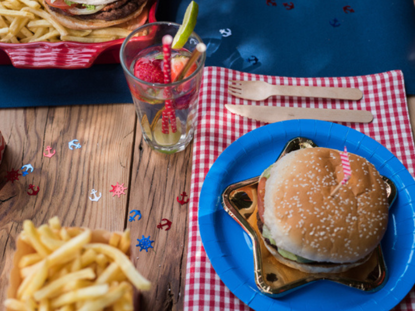 Leckere Burger auf coolem Partygeschirr - ein beliebtes und unkompliziertes Abendessen auf dem Kindergeburtstag