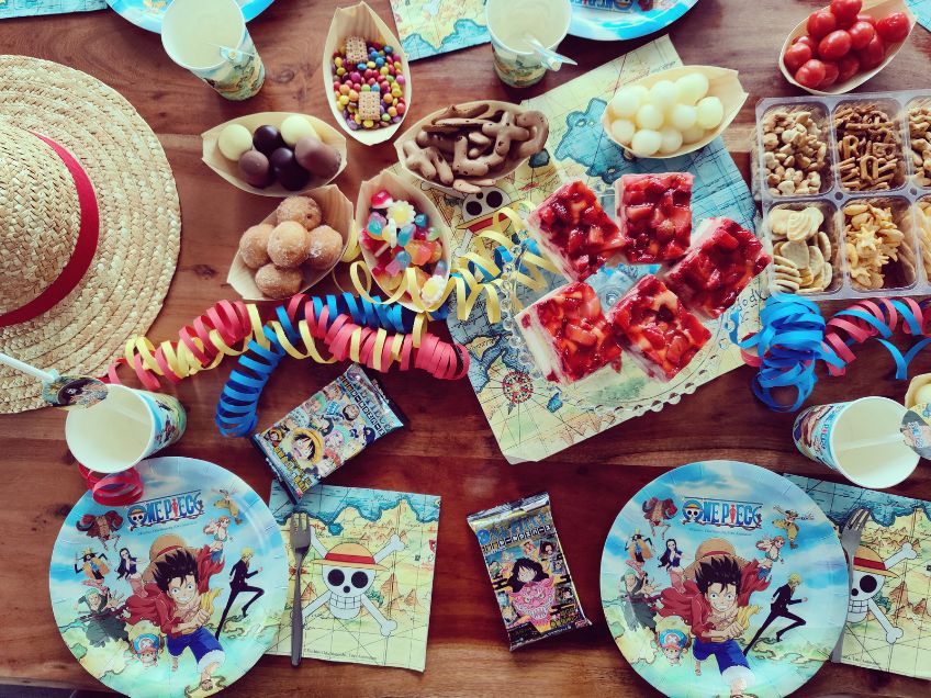 Snacks in Schiffchen-Formen auf dem bunten One-Piece-Geburtstagstisch