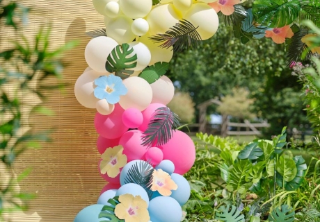 Bunte Ballongirlande mit exotischen Hibiskusblüten und Palmblättern aus Papier